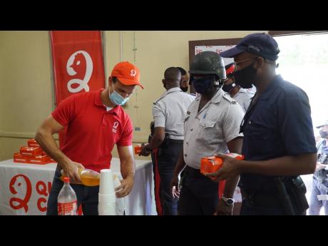 Benjamin Salmon ((left) of Quick Chick serves members of the Jamaica Constabulary Force, Half-Way Tree Police Station, over the National Heroes weekend. Forty members of the Jamaica Constabulary Force and the Jamaica Fire Brigade, both located at the Half-