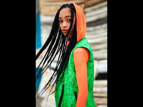Each look is complemented by box braids half the length of Davis’ body. Her hair and clothes flow effortlessly with her runway steps to create a lively editorial infused with a loud mash-up of bright colours.