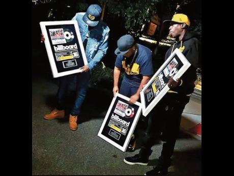 Producer Sean ‘Contractor’ Edwards and young members of the Wu-Tang Clan show off their most recent Billboard plaques, ordered for the album ‘Tropical House Cruises to Jamaica: The Reggae Collector’s Edition’. Getting your hands on one of those c