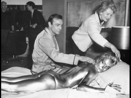 In this file photo dated April 20, 1964, James Bond, alias, Sean Connery, finds himself in a sticky situation with actress Shirley Eaton at Pinewood Studios, near London.  Miss Eaton was given a liberal coating of gold paint for a scene in the latest Bond