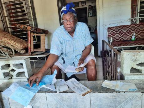 Letna Clarke lays out important documents to dry after they were soaked in her flooded home in Bull Bay, St Andrew, during rains last weekend.