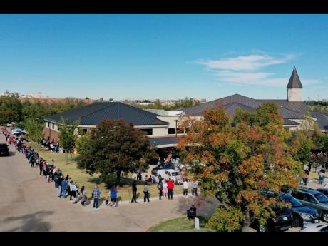 The line for early voting at a polling place in Oklahoma County on Friday, wraps around Edmond Church of Christ in Edmond, Oklahoma. People in this section of the line still have to wrap around the entire building to gain entrance to vote. Voters at the fr