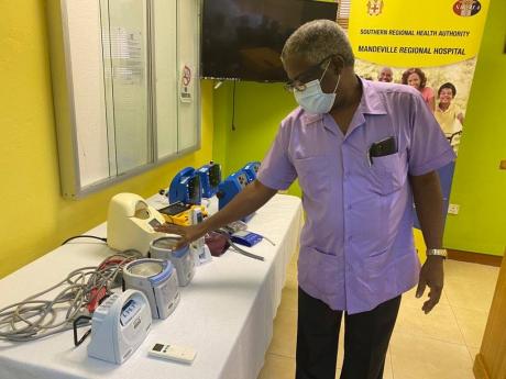 Dr Everton McIntosh, senior medical officer at the Mandeville Regional Hospital, explaining the purpose of the equipment donated to the hospital on Thursday at a handover ceremony. 