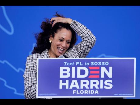 Democratic vice-presidential candidate Senator Kamala Harris gathers her hair as she speaks during a drive-in get-out-the-vote rally on Saturday, October 31 at Palm Beach State College in Lake Worth, Florida.