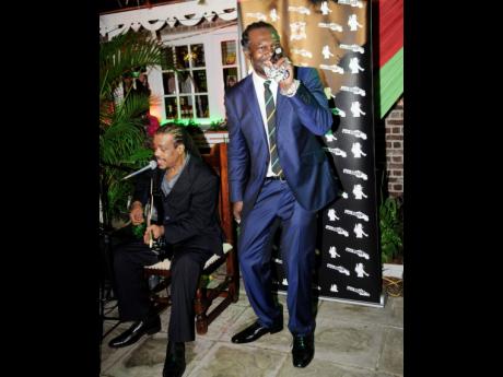 Levi Roots (right) performs at the official opening of his Levi Roots Store, held at Devon House on November 5, 2013. He is accompanied on the guitar by Dalton Browne. 