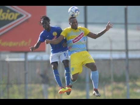  Waterhouse’s Shawn Lawes (right) goes up for an aerial challenge with Vere’s Devroy Grey during a Red Stripe Premier League match last season.
