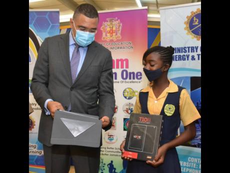 Prime Minister Andrew Holness talks with Shannaoyah Laird, recipient of a tablet, at a handover ceremony at Drews Avenue Primary and Infant School on Wednesday. Drews Avenue is located in the prime minister's St Andrew West Central constituency. 