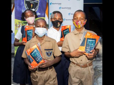 Barracks Road Primary School students Damani Curtis (front left), Hueroge Stanley (front right), Arkeila Drummond (back left), and Daneila Chambers show off their tablets received from New Fortress Energy Foundation.