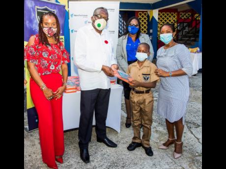 St James Custos Reverend Conrad Pitkin presents a tablet to Barracks Road Primary grade-six student Damani Curtis on behalf of New Fortress Energy Foundation. Also sharing in the occasion are (from left) Damia Dawes-Monthrope, third vice-president of the M