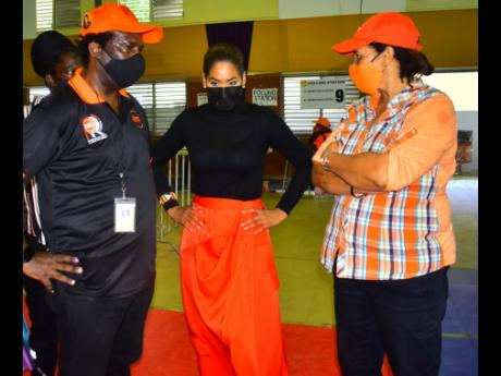 Lisa Hanna (centre) talks strategy with Comrades Patrick Roberts (left) and Karen Cross at The Mico University College on Saturday. Hanna lost her bid for the presidency by 296 votes.