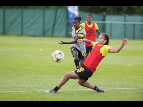 Reggae Girl Toriana Patterson (front) slides in to block a shot from teammate Jody Brown during a training session in Grenoble, France, at the FIFA Women’s World Cup on Sunday, June 9, 2019.
