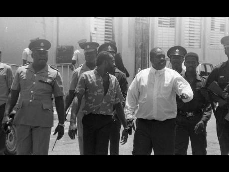 Lester Lloyd Coke, otherwise known as Jim Brown, Tivoli Gardens, West Kingston strongman, being escorted by police. 
