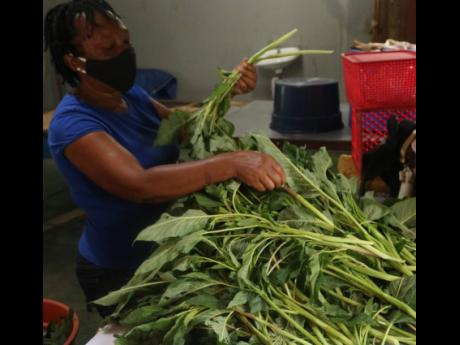 Manager at Farm Best Vegetables, Veronica Hamm, does quality-control checks on the limited supply of callaloo the company was preparing for delivery to a client yesterday.