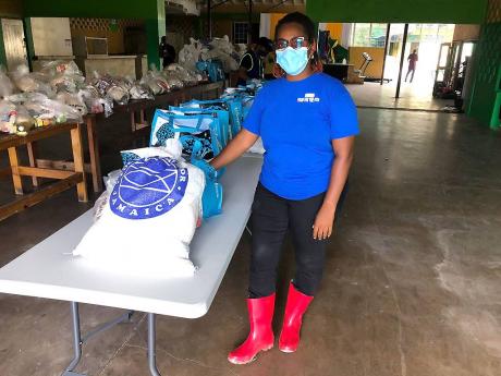 Kivette Silvera, executive at Food For the Poor, shows some of the relief items which were to be given to residents of New Haven in St Andrew yesterday. She said the team will now have to consider a new approach to complete the distribution.