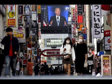 A screen shows a live broadcast of President-elect Joe Biden speaking Sunday, Nov. 8, 2020, at the Shinjuku shopping district in Tokyo. 