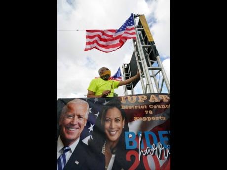 J.C. Garcia, with the Painter’s Union, secures an American flag to a trailer as he prepares it for a ‘Soul of the Nation Celebration ‘United as One’ Worker Caravan for Biden-Harris’, organised by South Florida unions to support President-elect Jo