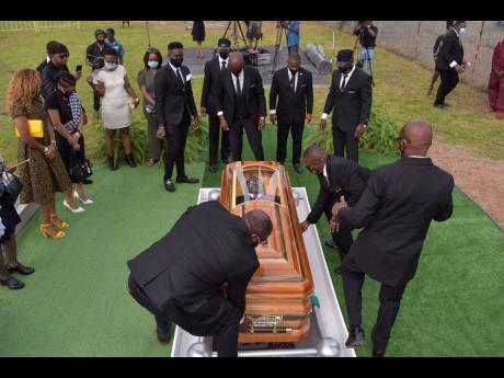 Pall-bearers lower the coffin bearing the body of late reggae icon Frederick ‘Toots’ Hibbert during Sunday’s interment service at National Heroes Park in Kingston. Hibbert, 77, died at the University Hospital of the West Indies in St Andrew on Septem