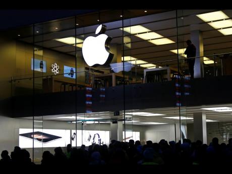 In this September 25, 2015 photo, people wait in front of the Apple store in Munich, Germany.