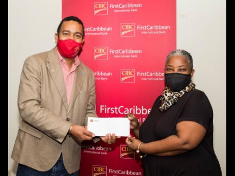 Lorna Laidley of the Church Services’ CLF Development Fund receives a cheque from Nigel Holness, managing director, CIBC FirstCaribbean International Bank, to benefit their Student Support Programme which provides book vouchers and bursaries for high- sc