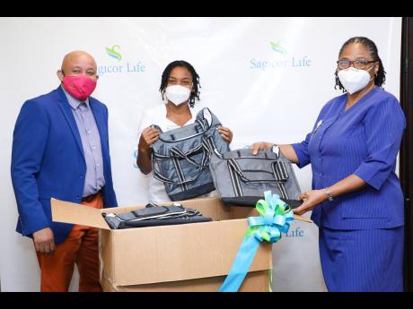 From left: Mark Chisholm, executive vice-president, Sagicor Life Jamaica – Individual Life Division, presents a donation of lunch bags to the nursing staff of the Kingston Public Hospital, represented by Diane Buckley-Smith, departmental nurse manager, a