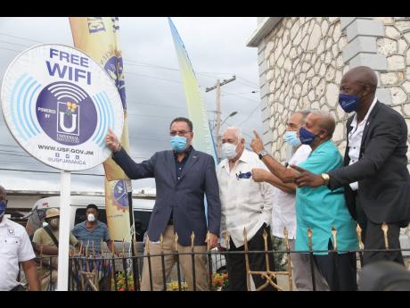 From left: Technology Minister Darly Vaz unveils a sign to reflect the launch of the free Wi-Fi service in May Pen, Clarendon, as Clarendon Central Member of Parliament Mike Henry, Clarendon Custos William Shagoury, May Pen Mayor Winston Maragh and Univers