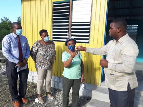 The Rev Devere Nugent (right) hands over keys to two houses to Deacon Novelett Anderson for William Knibb Baptist Church’s Social Housing. Others (from left)  are the moderator and church secretary, Deacon Lorna Jackson.