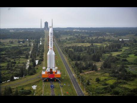 In this November 17 photo released by China’s Xinhua News Agency, a Long March-5 rocket is moved at the Wenchang Space Launch Site in Wenchang in southern China’s Hainan Province. 