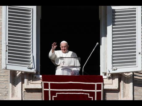 Pope Francis waves as he arrives for the Angelus noon prayer from the window of his studio overlooking St Peter’s Square at the Vatican on Sunday.