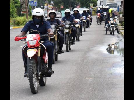Members of the Jamaica Constabulary Force motorcycle unit engage in a training ride along Brunswick Avenue in Spanish Town on Tuesday. A man was slain on the road on Monday, one of eight people killed in the St Catherine North Police Division over 48 hours