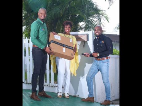 Daren Miller (left), executive chairman of BluShip Cargo and Freight, delivers a package to a customer, Jacqueline Knight-Campbell (centre), managing director of Top Klass Events. Sharing in the moment is Lemar James, chief executive officer of BluShip Car