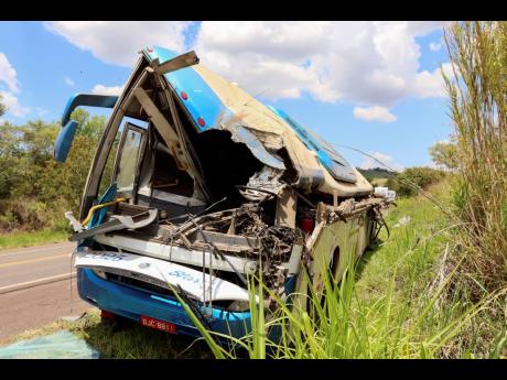 The wreckage of a bus that was carrying employees of a textile company remains on the shoulder of a road in the municipality of Taguai, about 350 kilometres  from Sao Paulo, Brazil, yesterday. 