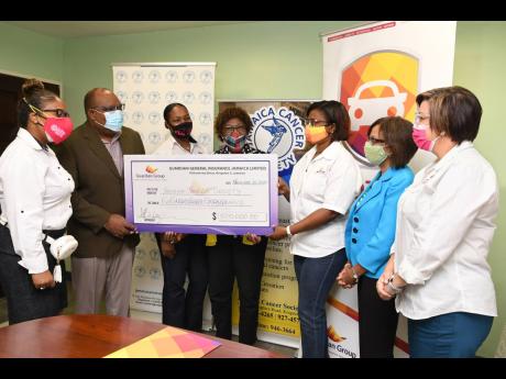 Representatives of Guardian General Jamaica Limited present a cheque valued at $500,000 to representatives of the Jamaica Cancer Society, Michael Leslie (second left) and Elvy Passley (fourth left).  The funds are proceeds from the sale of 400 Queen Guard 