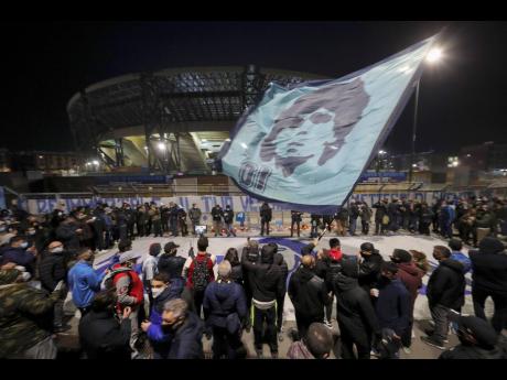 People gather outside the San 
Paolo Stadium to 
pay homage to late football legend Diego Maradona, in Naples, Italy, yesterday. Maradona was 60. 