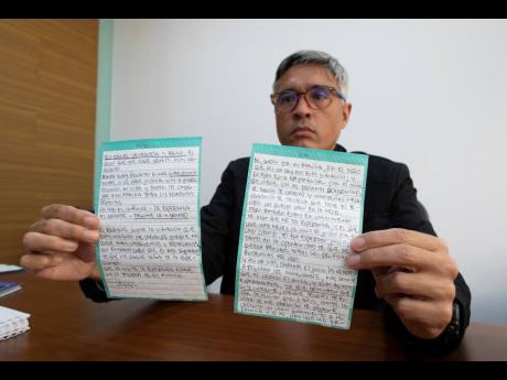 Jesus Loreto, an attorney representing Tomeu Vadell, one of six US oil executives jailed for three years in Venezuela, shows a letter written by Vadell, in Caracas, Venezuela, yesterday.