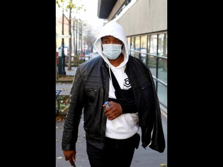 Music producer identified only by his first name, Michel, is pictured on his way to the Inspectorate General of the National Police, known by its French acronym IGPN, in Paris, yesterday.
