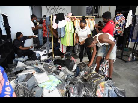 Shoppers go through merchandise to cash in on Black Friday deals at the Fierce by Dre clothing store along Constant Spring Road in St Andrew yesterday.