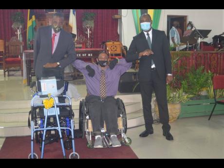 Andrew East (in wheelchair), president of the Cornwall Combined Disabilities Association (CCDA), in a photo op with the Reverend Courtney Walters (left), pastor of Calvary Baptist Church in Montego Bay, St James, and Labour and Social Security State Minist
