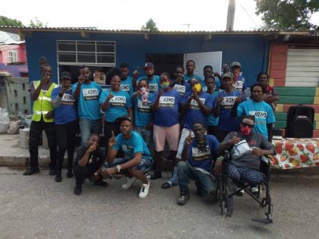Akino Page (stooping, second left) and most of the core members of the Dream Team pose for a photo last Friday outside their latests completed project, a ‘chef shop’ in Trench Town, St Andrew.