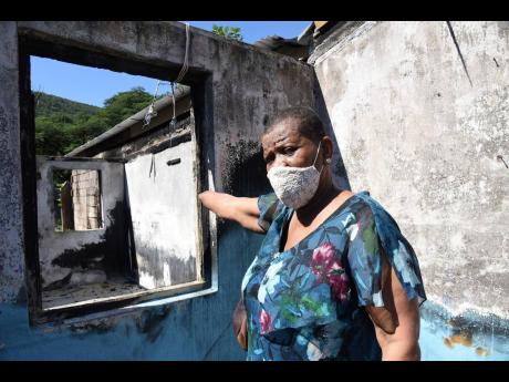 Miriam Lindsay gestures towards a room in her razed house in Hermitage on Sunday. 