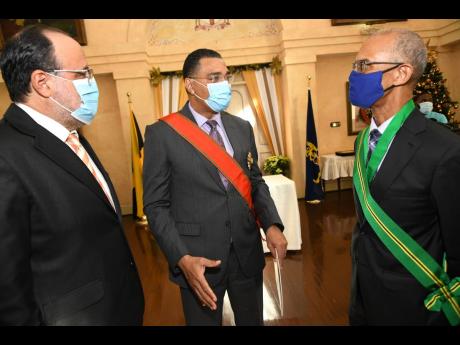 Prime Minister Andrew Holness (centre) and Opposition Leader Mark Golding (left) catch up with Justice Patrick Brooks after the jurist was sworn in as president of the Court of Appeal at King’s House on Monday. 