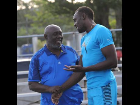 In this file photo from June 2016, Usain Bolt (right) has a light moment with coach Glen Mills during a Racers Track Club training session at the UWI/Usain Bolt Track on the UWI Mona Campus.