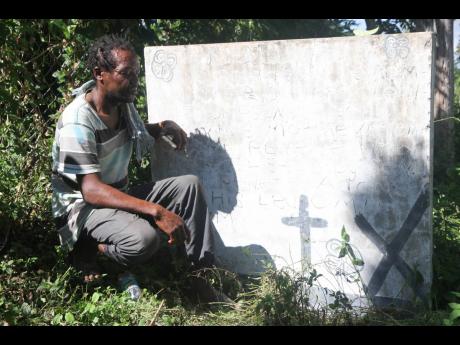 Rohan Thomas, who was the chef at the house in Kraal, Clarendon, when the Crime Management Unit led by Reneto Adams shot and killed four persons on May 7, 2003. Here on December 12, 2020, Thomas stoops beside a monument erected in memory of those who died.