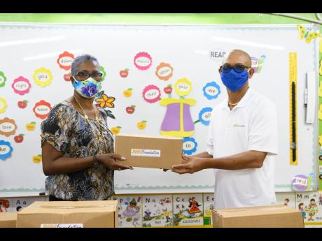 Monica Smiley, principal of Race Course Primary School, accepts food packages from JWNF volunteer Rohan Robinson.