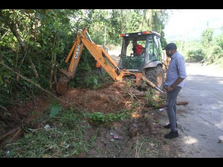 Clarendon North Central Member of Parliament Robert Nesta Morgan oversees work by a tractor operator in his constituency on Saturday, December 12.
