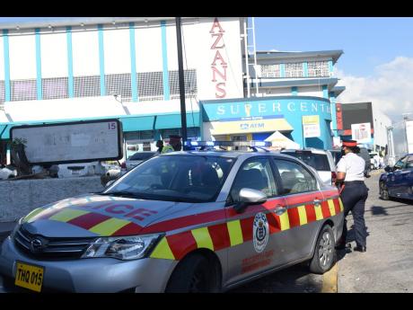 A police service vehicle is seen outside the Azan Supercentre where an off-duty soldier reportedly shot and injured an attendant on Thursday.
