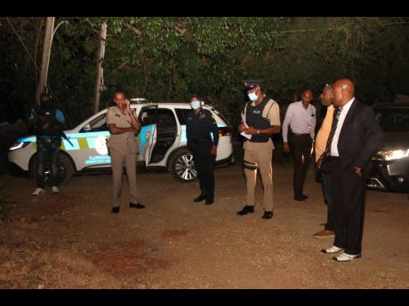 Assistant Commissioner of Police Micheal Smith (right), head of the Area 3 police, leading a high-level police team on a tour of Effortville in Clarendon last night. Eight persons were shot in the community, five fatally, between Wednesday and Thursday. Ot