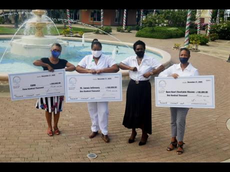 Angella Whitter (second right), managing director of the Whitter Group of Companies, with representatives of three St James-based charity groups that collectively received $500,000 in donations from Whitter Village in Ironshore, St James. Also pictured (fr
