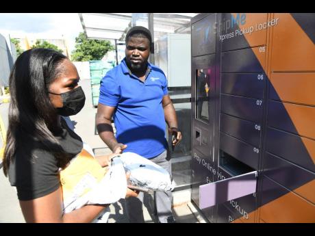 Leighton Sellars, store assistant supervisor at ShipMe, assists Jay-Ann Gayle with her package at the ShipMe office on Ripon Road, New Kingston, on Monday.