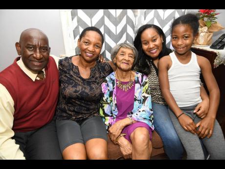 Elsie Smikle is flanked by (from left) son-in-law Collie Petgrave, daughter Diane Petgrave, granddaughter Candice Petgrave and Daiskie Shawat at the Petgraves’ home in Stadium Gardens in Kingston yesterday. The Walderston, Manchester, native celebrates h