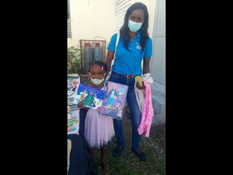 Five-year-old Madison Lee shows off a doll and book her mother, Alicia McKenzie, picked out during a treat hosted by the Shak’s Hope Foundation and the Sickle Cell Unit recently. Madison was diagnosed with sickle-cell disease at birth.